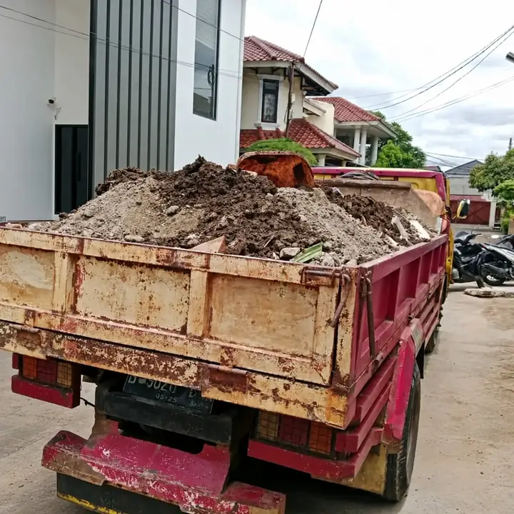 Truk bermuatan tanah dan puing di depan perumahan